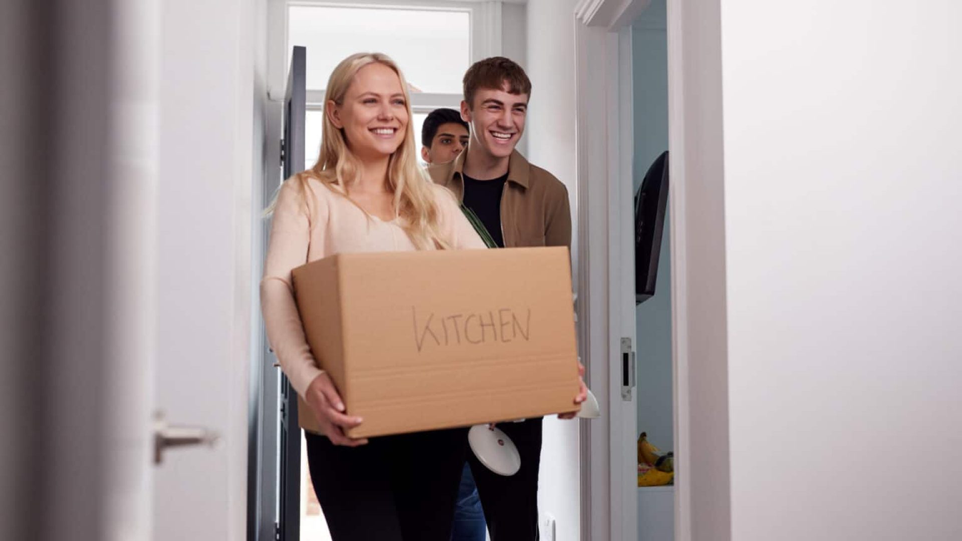 Group Of College Student Carrying Boxes Moving Into Accommodation Together